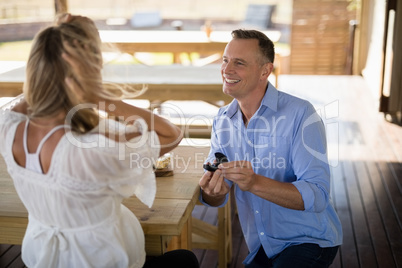 Man giving engagement ring to surprised woman