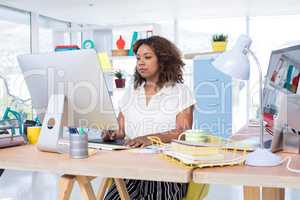 Female executive working over graphic tablet at her desk