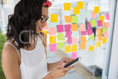 Smiling female executive using mobile phone