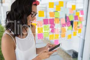 Smiling female executive using mobile phone