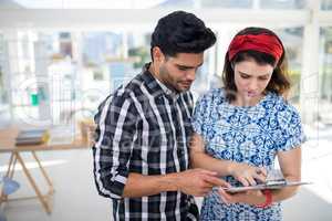 Couple discussing over clipboard in the office