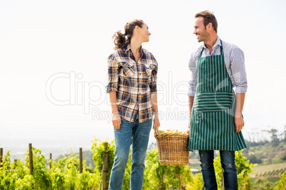 Couple holding basket at vineyard