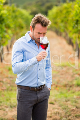 Young man smelling red wine