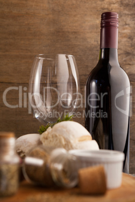 Wine bottle by glass with spice and bread on table
