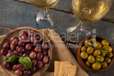 Black and green olives served by white wine