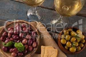 Black and green olives served by white wine