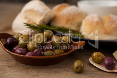 Olives in plate by bread