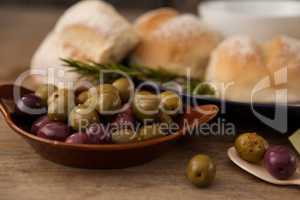 Olives in plate by bread