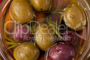 Close up of olives and herb with oil