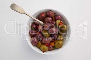 Olives and spices with spoon in bowl