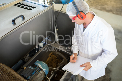 Technician examining processing machine