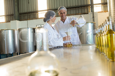 Technicians examining olive oil