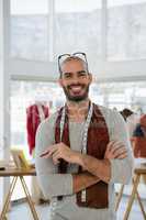 Portrait of smiling male designer with arms crossed in workshop