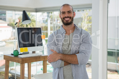 Portrait of smiling male designer standing in office