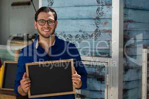 Smiling businessman holding writing slate