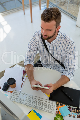 High angle view of graphic designer using tablet computer at desk