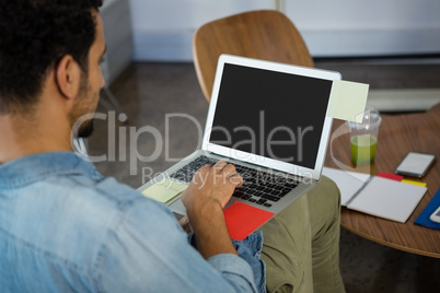 Man working while using laptop in office