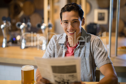 Man holding newspaper in a restaurant