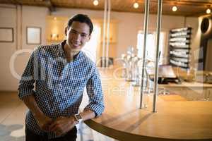 Smiling man standing at counter in restaurant