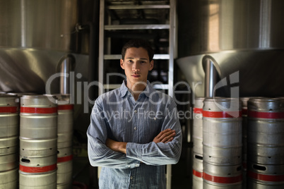 Manager standing with arms crossed in warehouse