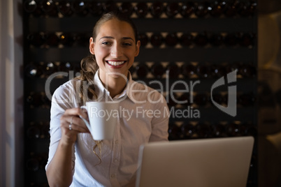 Smiling woman having coffee in cafe