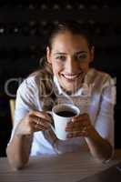 Smiling woman having coffee in cafe