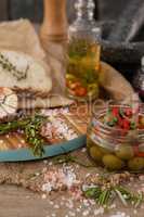 Spices and herbs by olives in container