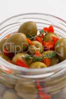 Green olives with herbs in jar