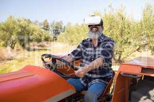 Happy man using virtual reality headset in tractor