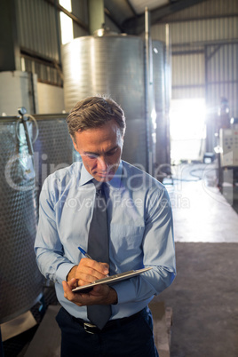 Attentive manager writing in clipboard