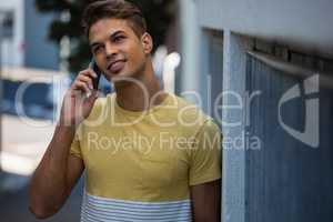 Young man looking away while talking on mobile phone