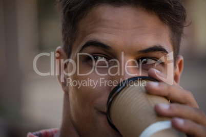 Young man looking away while having drink