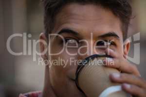 Young man looking away while having drink