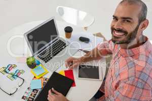 Portrait of graphic designer using tablet computer at desk in office
