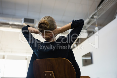 Businesswoman with hands behind head relaxing at office