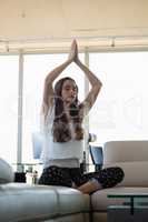 Young businesswoman doing yoga at office