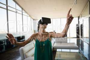 Woman using virtual reality simulator in office