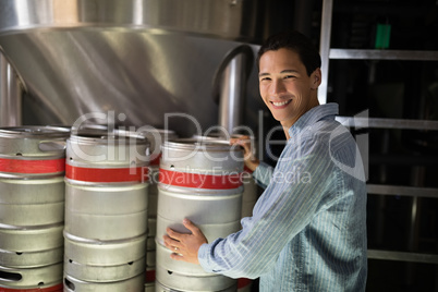 Manager checking beer keg in warehouse