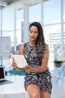 Female executive using digital tablet at desk