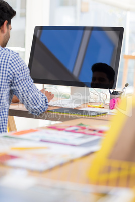 Graphic designer working on computer at desk