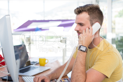 Male executive talking on telephone at desk