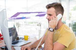 Male executive talking on telephone at desk