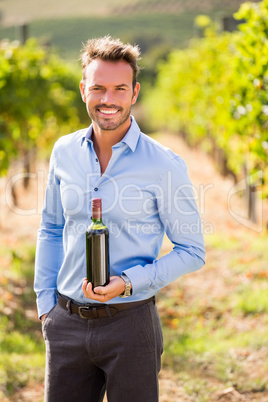 Portrait of handsome man holding wine bottle