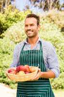 Smiling man with apple basket looking away