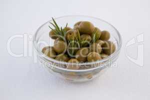 Close up of green olives with herb in bowl