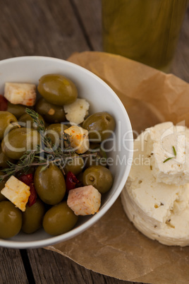Close up of green olives with cheese on wax paper