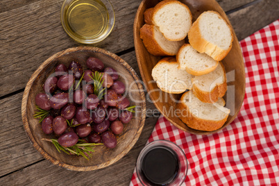 Overhead view of olives and bread in plate on table