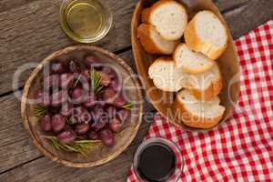 Overhead view of olives and bread in plate on table
