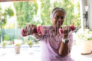 Close up portrait of woman exercising with dumbbell