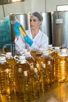 Female technician examining olive oil